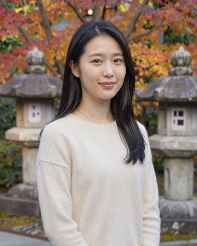 Japanese woman smiling gracefully in a traditional garden with autumn maple trees, representing Japanese women dating culture