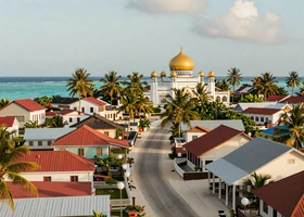 A traditional Maldivian island village with mosque and turquoise lagoon - home to warm-hearted Dhivehi women